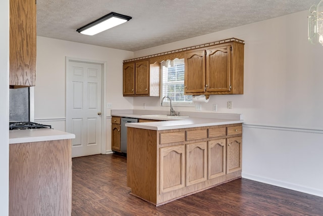 kitchen featuring sink, a textured ceiling, stainless steel dishwasher, and dark hardwood / wood-style flooring