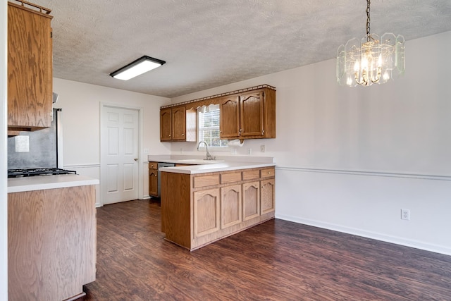 kitchen featuring a textured ceiling, dark wood-type flooring, an inviting chandelier, sink, and hanging light fixtures