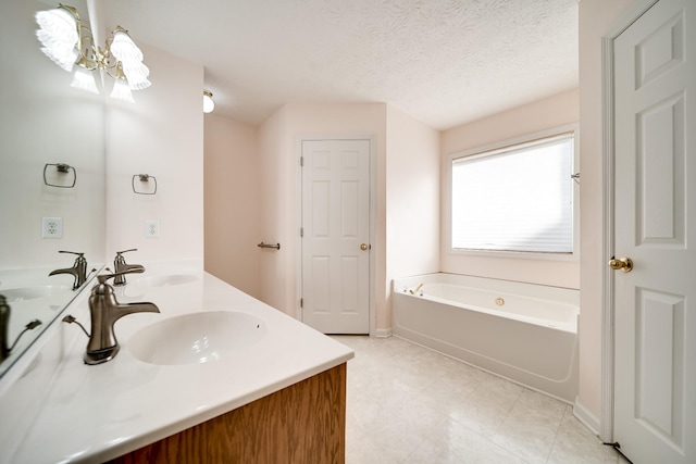 bathroom featuring a textured ceiling, a washtub, and vanity