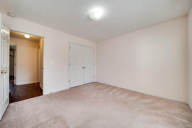 unfurnished bedroom with carpet, a closet, and a textured ceiling