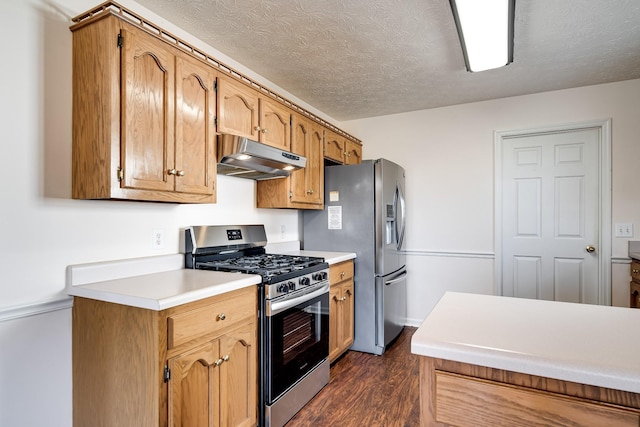 kitchen with dark hardwood / wood-style flooring, stainless steel appliances, and a textured ceiling