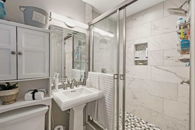 bathroom with toilet and a shower with shower door