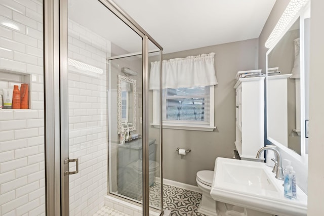 bathroom featuring toilet, tile patterned flooring, a shower with shower door, and sink