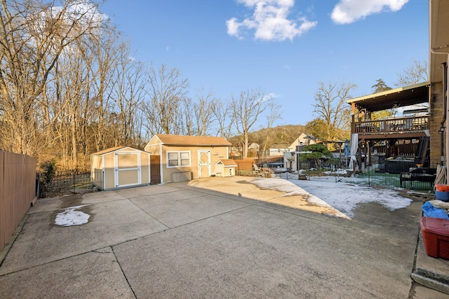 exterior space featuring a patio area, a deck, and a storage shed