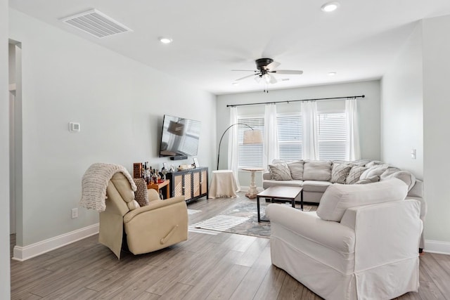 living room with light wood-type flooring and ceiling fan