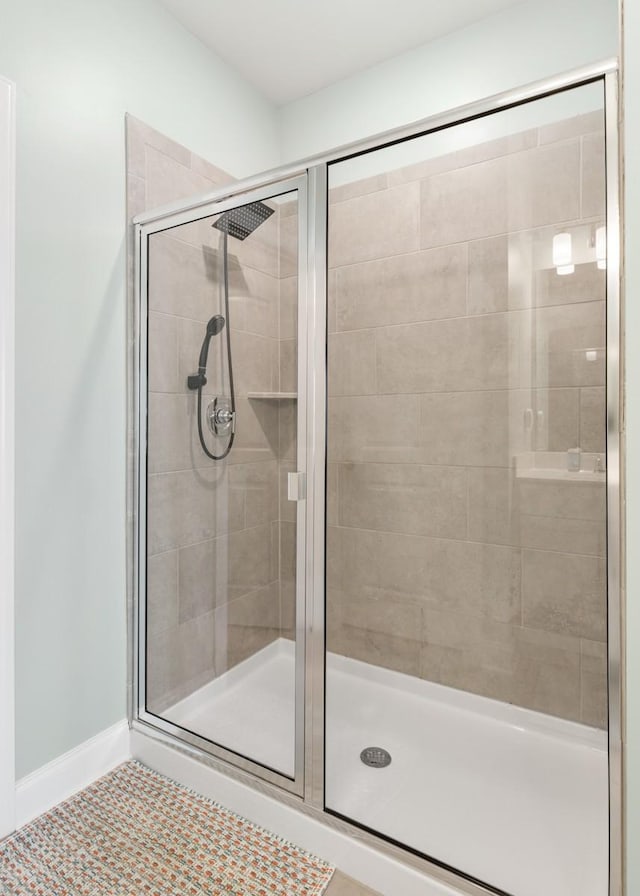 bathroom featuring a shower with door and tile patterned flooring