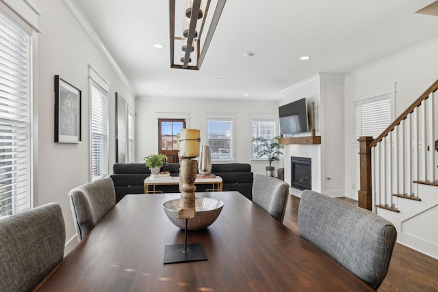 dining room with a fireplace, ornamental molding, and dark hardwood / wood-style floors