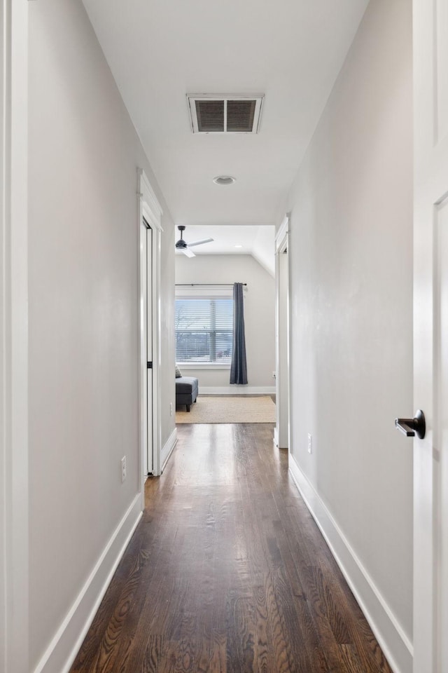 corridor featuring dark hardwood / wood-style flooring and vaulted ceiling