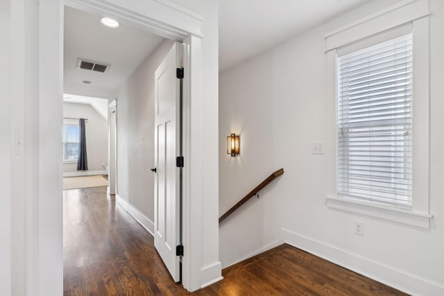 hallway featuring lofted ceiling and dark wood-type flooring