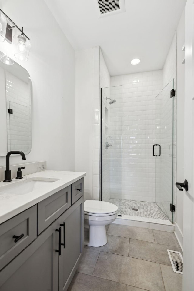 bathroom with vanity, an enclosed shower, and toilet