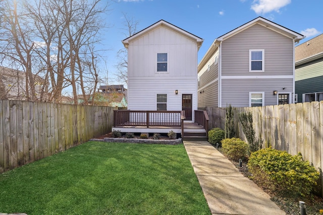 rear view of house with a lawn and a deck