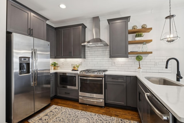 kitchen with sink, stainless steel appliances, light stone countertops, decorative backsplash, and wall chimney range hood