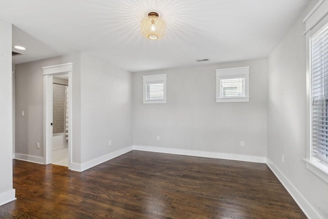 empty room featuring dark hardwood / wood-style flooring and a healthy amount of sunlight