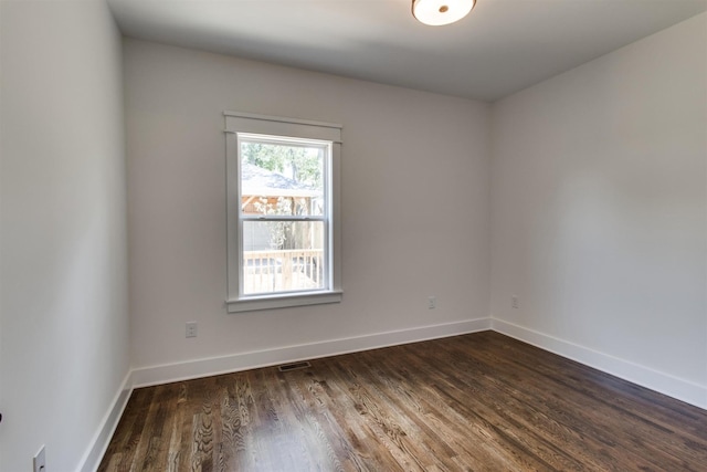 unfurnished room with dark wood-type flooring