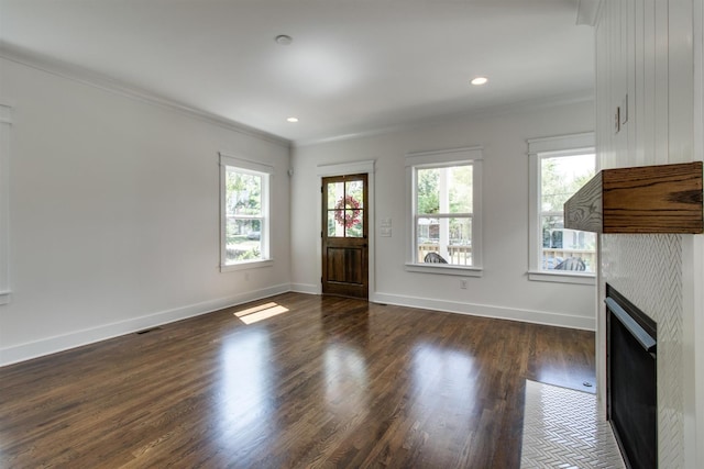 unfurnished living room featuring a fireplace, ornamental molding, and dark hardwood / wood-style flooring