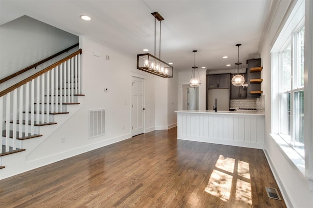 unfurnished living room featuring ornamental molding and dark hardwood / wood-style floors