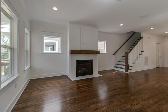 unfurnished living room featuring ornamental molding and dark hardwood / wood-style flooring