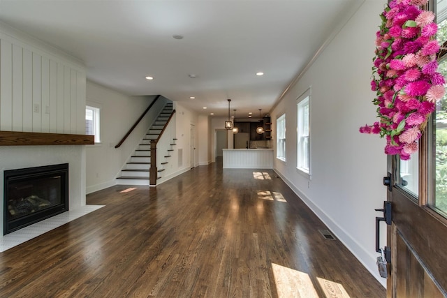 living room with ornamental molding, a fireplace, and dark hardwood / wood-style flooring