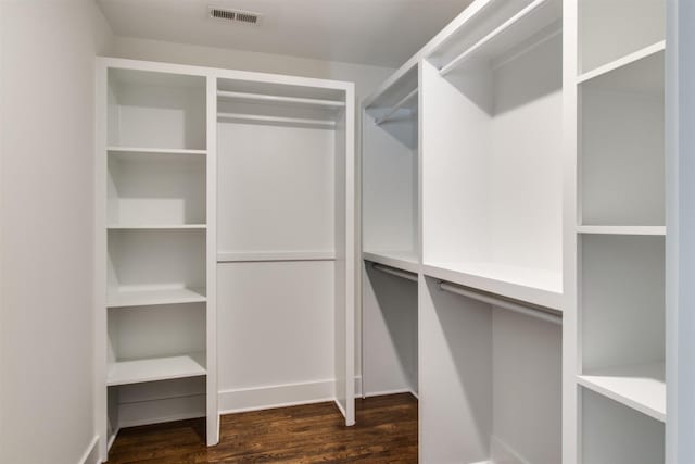 spacious closet featuring dark hardwood / wood-style flooring