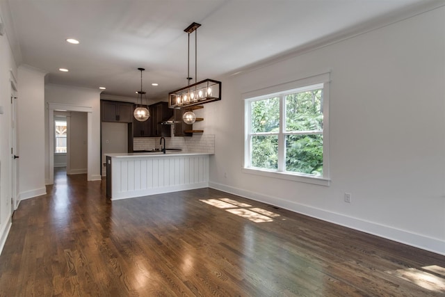 unfurnished living room featuring crown molding, dark hardwood / wood-style flooring, and sink