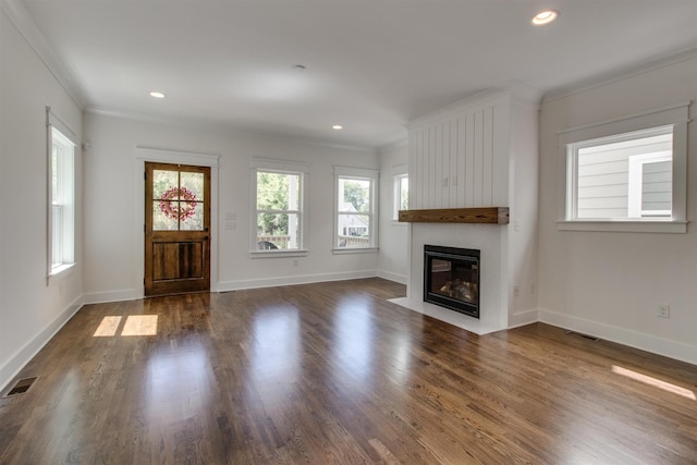 unfurnished living room featuring dark hardwood / wood-style flooring and ornamental molding