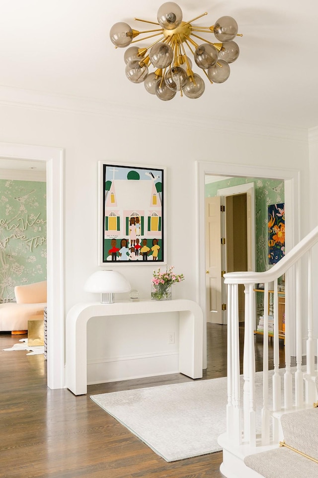 interior space with hardwood / wood-style floors, ornamental molding, and an inviting chandelier