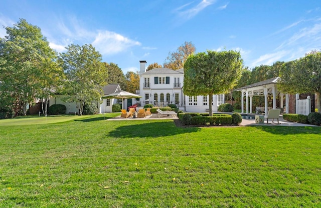 rear view of property with a gazebo and a yard