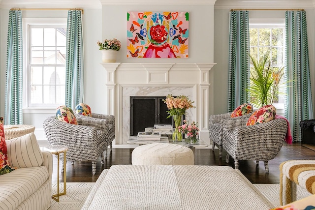 sitting room with wood-type flooring, a fireplace, and crown molding