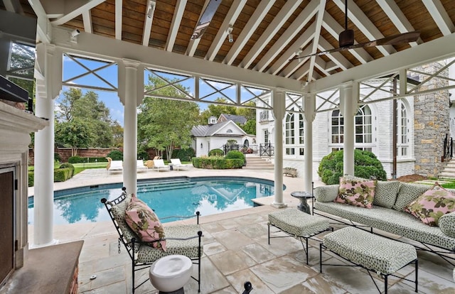 view of pool featuring ceiling fan, glass enclosure, outdoor lounge area, and a patio