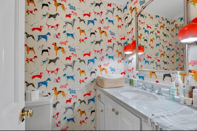 bathroom with toilet, vanity, and crown molding