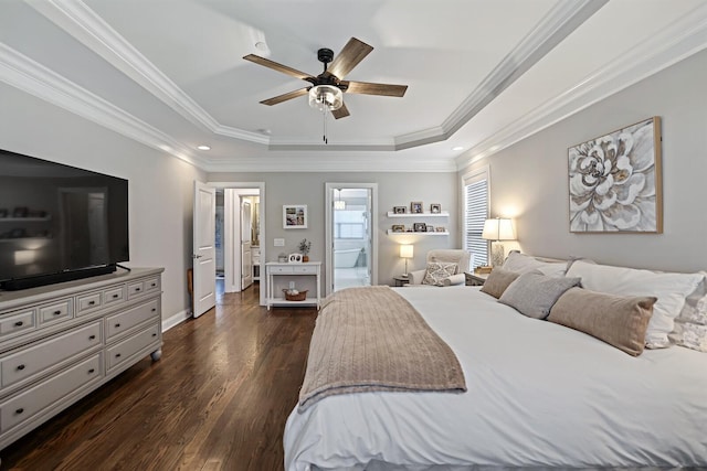 bedroom featuring a tray ceiling, dark wood-type flooring, ornamental molding, ceiling fan, and ensuite bathroom