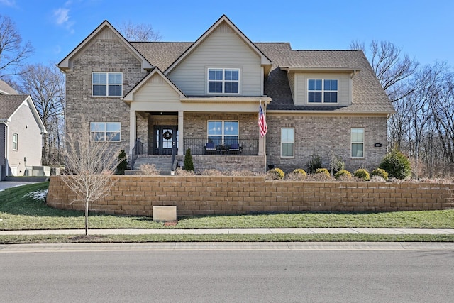 craftsman inspired home featuring a porch and a front yard