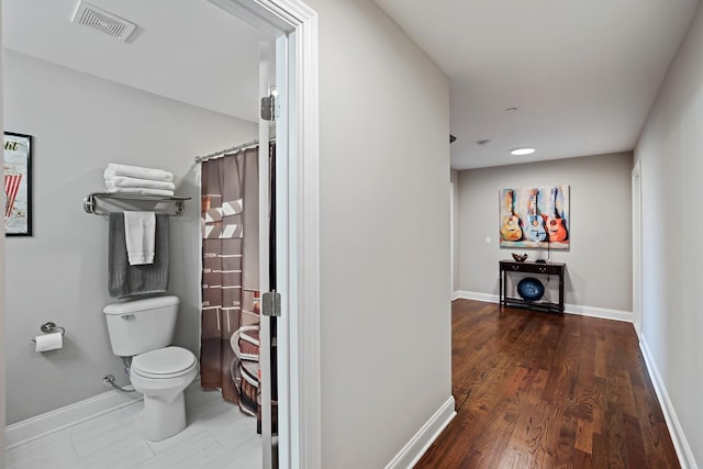 interior space with toilet and hardwood / wood-style flooring