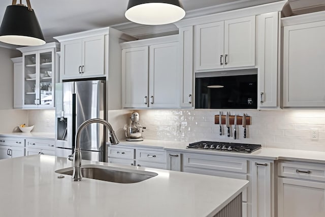 kitchen featuring hanging light fixtures, white cabinets, and appliances with stainless steel finishes