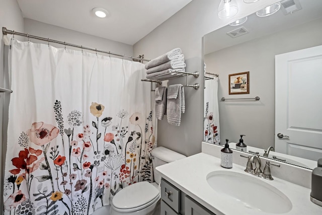 bathroom with toilet, walk in shower, and vanity