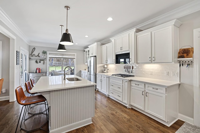 kitchen with appliances with stainless steel finishes, sink, and white cabinetry