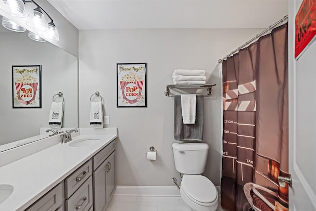 bathroom with toilet, vanity, and tile patterned flooring