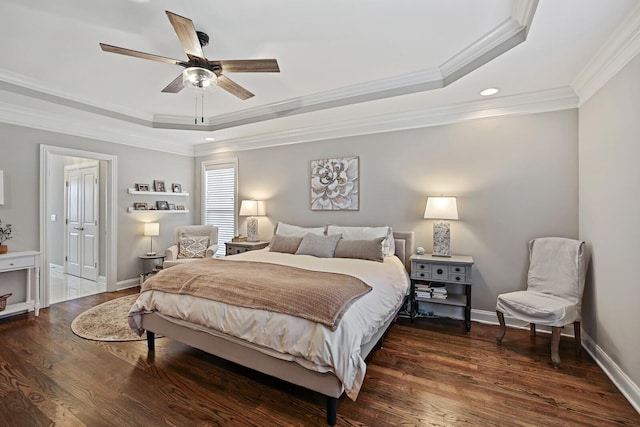 bedroom featuring ceiling fan, dark wood-type flooring, a tray ceiling, and ornamental molding