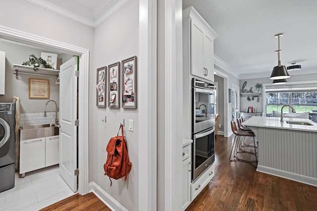 kitchen with sink, pendant lighting, white cabinets, and a kitchen breakfast bar