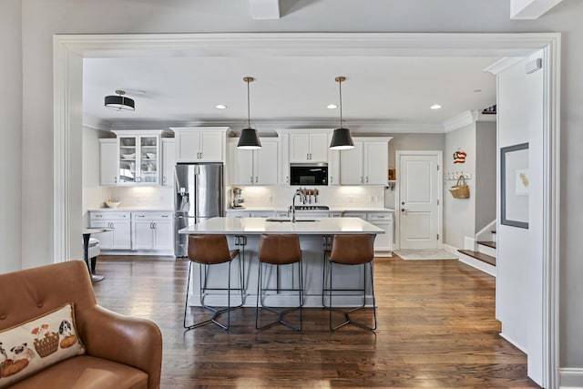 kitchen featuring decorative light fixtures, white cabinetry, black microwave, backsplash, and stainless steel fridge with ice dispenser