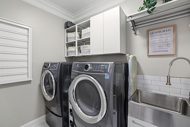 washroom featuring cabinets, washer and clothes dryer, ornamental molding, and sink