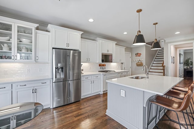 kitchen with decorative light fixtures, decorative backsplash, sink, white cabinetry, and stainless steel appliances