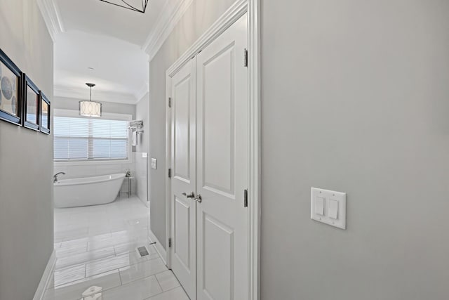 hallway with crown molding and light tile patterned flooring