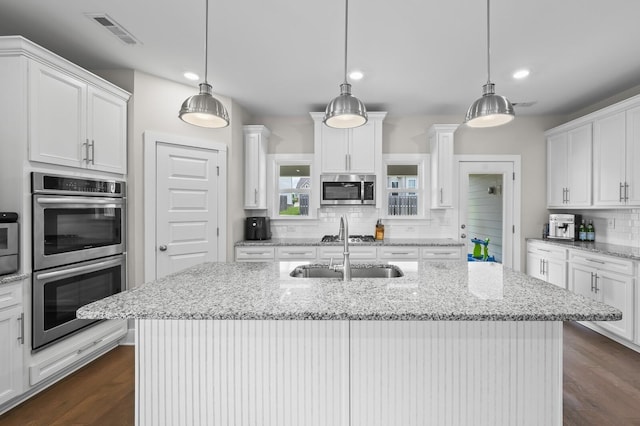 kitchen featuring appliances with stainless steel finishes, pendant lighting, and white cabinets