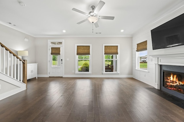 unfurnished living room with ceiling fan, a wealth of natural light, and ornamental molding