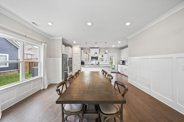 dining space with dark hardwood / wood-style floors and ornamental molding