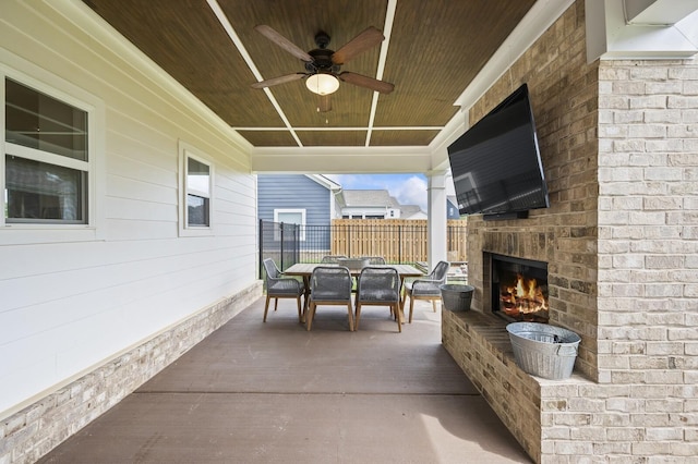 view of patio with ceiling fan and an outdoor brick fireplace