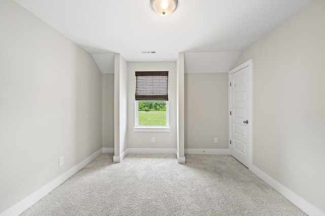 unfurnished bedroom with light carpet and vaulted ceiling