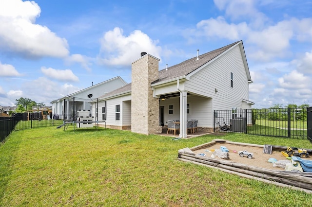 back of house featuring ceiling fan, a patio area, and a yard