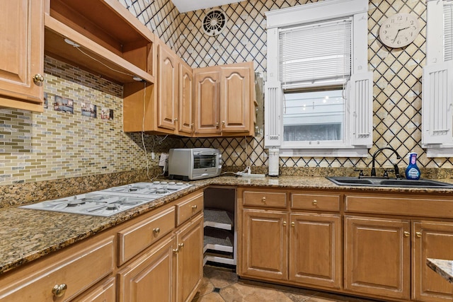 kitchen with extractor fan, backsplash, light stone countertops, white gas stovetop, and sink